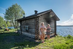 Vanhan saunan edessä seisoo kaksi naista.