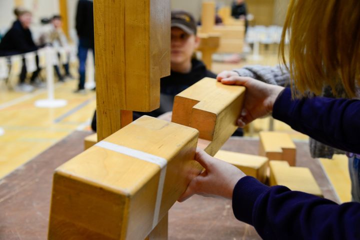 Nuoret kokoavat isoa puista pirunnyrkkiä.