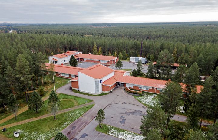 Iso koulukiinteistö, taustalla metsää.