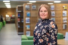 Toimialajohtaja Sari Veijola seisoo kirjaston edessä.