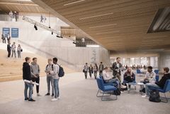 Modernin koulun avoin aula, jossa oppilaita seisoo ja istuu keskustelemassa näköisillä alueilla.