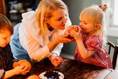 Nainen näyttää lapselle jouluapelsiinia