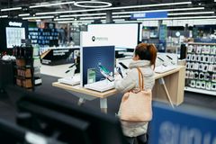 Nainen tutkii Motorola-merkkistä puhelinta Gigantin myymälässä.