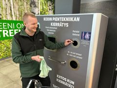 Mies palauttaa käytöstä poistettuja paristoja kaupan keräyspisteellä