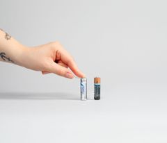 Käsi teippaamassa paristojen virtanapoja