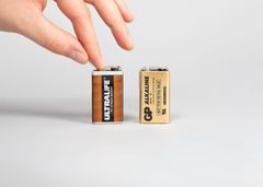 Käsi teippaamassa paristojen virtanapoja