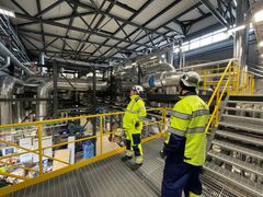 Swecon työntekijöitä teollisuushallissa turvavarusteissa.