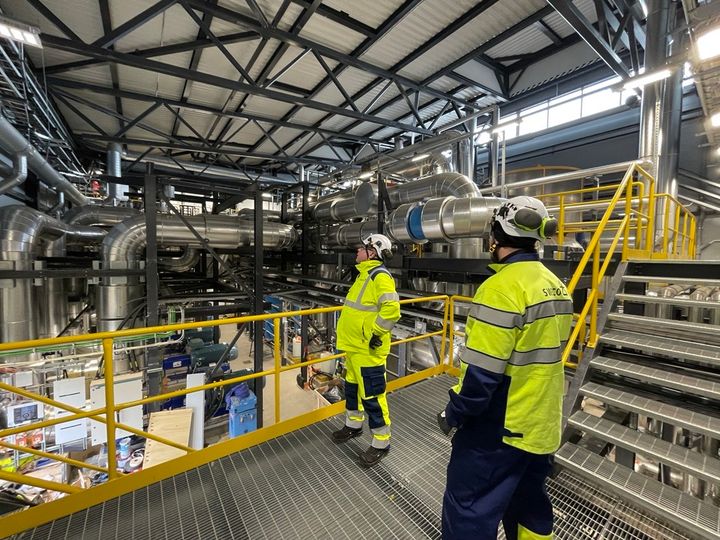 Swecon työntekijöitä teollisuushallissa turvavarusteissa.