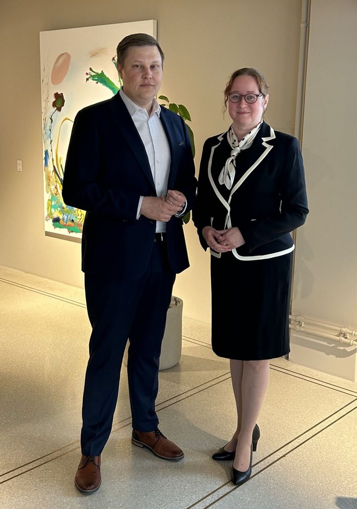 Tuomas Salminen and Kirsi Hassinen smiling and standing in the hall.
