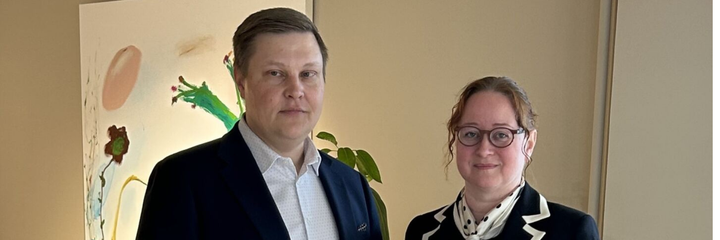 Tuomas ja Kirsi seisovat käytällä ja hymyilevät.