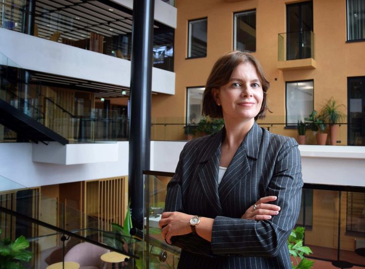 Johanna Tavia hymyilee toimistossa.