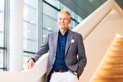 Johan Sandell seisoo portaikossa kasvot kameraan päin. Hänen oikealla puolellaan on ikkunaseinä.