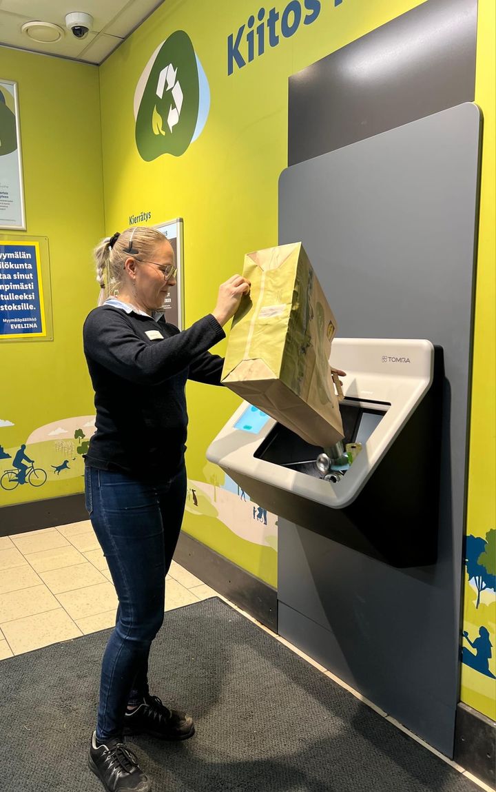 Eveliina Väätäinen testaa uutta pullonpalautusautomaattia.