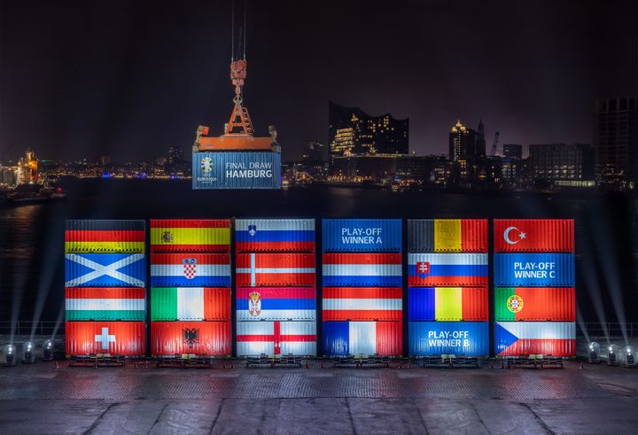 Port workers in Hamburg stack containers with flags of the EURO 2024 teams in accordance with the Final Draw