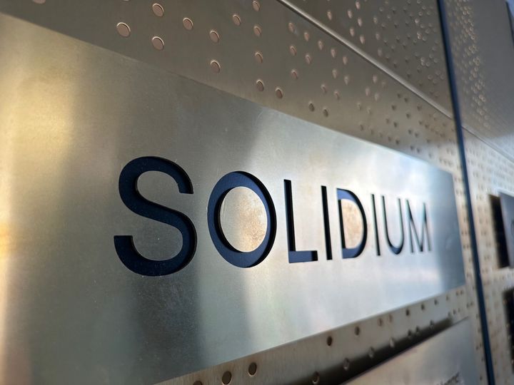 Läheltä otettu kuva metallisesta "SOLIDIUM"-logosta.