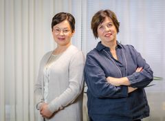 Kaksi naista, tilitoimistoammattilaisia, seisoo vierekkäin hymyillen kameralle.