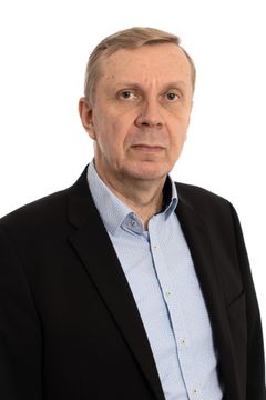 En medelålders man i mörk kostym. Står och tittar in i kameran. Självsäker uppsyn.