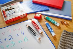 Valkotaululle kirjoitettuja numeroita, pöydällä eri värisiä STABILO MARKdry -valkotaulukyniä.