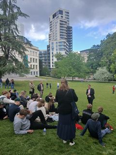 Osallistujaryhmä istumassa nurmikolla ulkona Brysselissä.