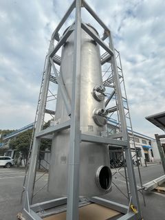 Kuvassa on 7,5 metriä korkea terässäiliö, joka on bioreaktori. Säiliö on kehikon sisällä ja sijaitsee ulkona teollisuusalueella.