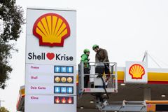 Greenpeacen aktivistit päivittivät Shellin huoltoasemien hinnastoja emojeille, joissa kerrottiin öljy-yhtiöiden voitoista ja ilmastosta Saksan Hampurissa lokakuussa.