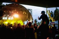 Konsertti Tykkimäellä, yleisössä lapsi istuu aikuisen harteilla.
