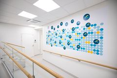 Terveysaseman käytävä, jossa seinällä värikäs seinämaalaus ja kaiteet molemmin puolin.