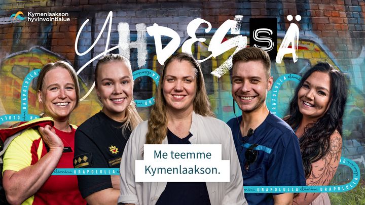 Viisi hymyilevää henkilöä seisoo värikkään graffitiseinän edessä. Teksti: "Yhdessä - Me teemme Kymenlaakson."