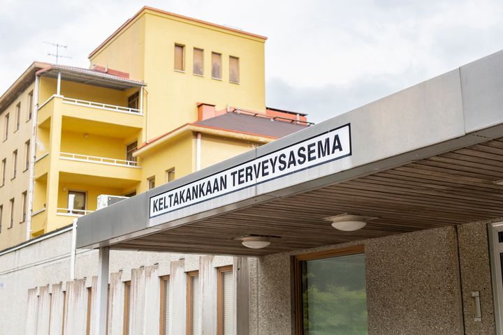 Keltakankaan terveysaseman sisäänkäynti ja taustalla keltainen kerrostalo.