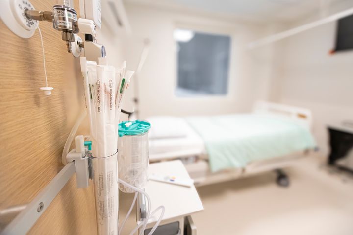 Sairaalan osastohuone, jossa sänky ja hoitovälineitä.