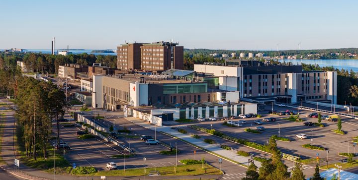 Ilmakuva Kymenlaakson keskussairaalasta vehreässä ympäristössä, taustalla järvimaisema.