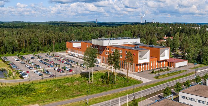 Ilmakuva Ratamokeskuksesta, jota ympäröi parkkipaikka ja vehreää metsää.