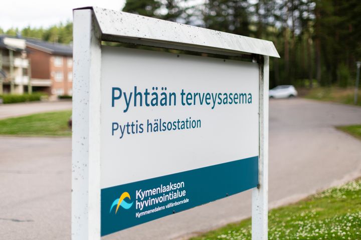 Kyltti, jossa lukee "Pyhtään terveysasema" ja "Pyttis hälsostation". Kymenlaakson hyvinvointialueen logo alhaalla.