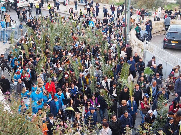 Kulkue Jerusalemissa palmusunnuntaina 2023, ihmiset heiluttavat palmunoksia ja liikkuvat kohti vanhaakaupunkia.