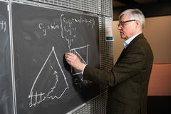 Esko Ukkonen kirjoittaa matemaattista yhtälöä liitulaululla.