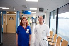 Sinipaitainen naishoitaja ja valkotakkinen mieslääkäri seisovat päivystysvastaanoton käytävällä.