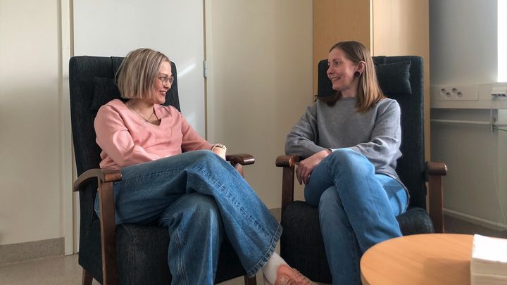 Två personer sitter och ler åt varandra.