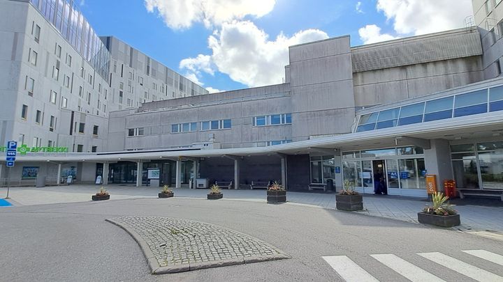 På bilden en grå byggnad med betongvägg.