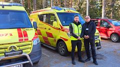 Två män står farmför en ambulans.