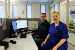 Mies ja nainen istuvat toimistossa tietokoneiden ääressä.