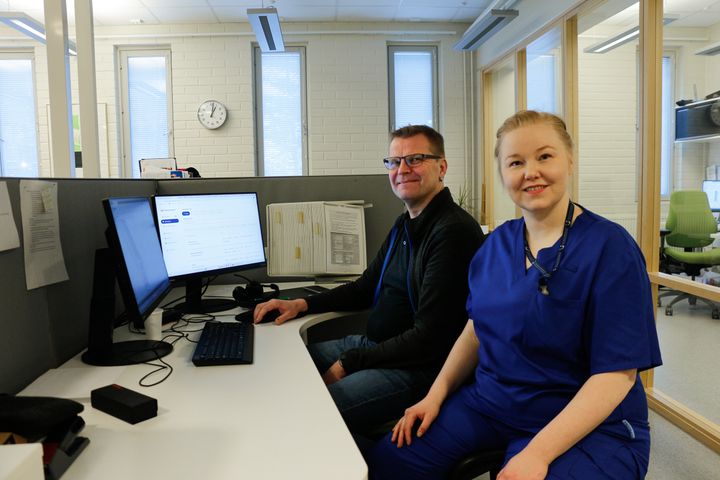 Mies ja nainen istuvat toimistossa tietokoneiden ääressä.