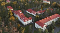 En bild som påminner om flygfotot av de stora, herrgårdsliknande byggnaderna i Roparnäsområdet. Ilmakuvaa muistuttava kuvannos Huutoniemen alueen isoista, kartanomaisista rakennuksista.