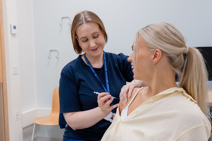 En skötare ger en vaccination i överarmen.