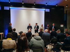 Paneelikeskustelu avaruusstrategian tulevaisuudesta, useita henkilöitä seisoo puhujana tilan etualalla.