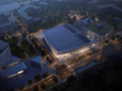 Ilmakuva kaupunkimaisemasta yöllä, valaistu rakennus keskellä.