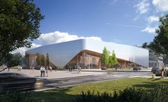 Moderni rakennus, jossa alumiini- ja lasijulkisivut sekä puuta. Rakennuksen muoto jäljittelee lentokoneiden liikkeitä. Eteen avautuu laaja piha, ja taustalla on sininen taivas.