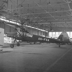 Vanha lentokone Fieseler Fi-156 K-1 Storch sisällä Malmin lentoaseman hallissa.