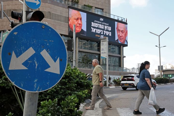 Pedestrians walk past an advertisement featuring Israel's Prime Minister Benjamin Netanyahu (R) of the Likud party and the country's former chief of the general staff and leader of the Yasher centrist political party Gadi Eisenkot, along a street in Ramat Gan on September 23, 2026. Israel heads to the polls on October 27 in its first election since the October 7, 2023, Hamas-led attack, in what is seen as a referendum on Netanyahu.