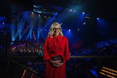Katja Ståhl orkesterin edessä punaisessa mekossa.