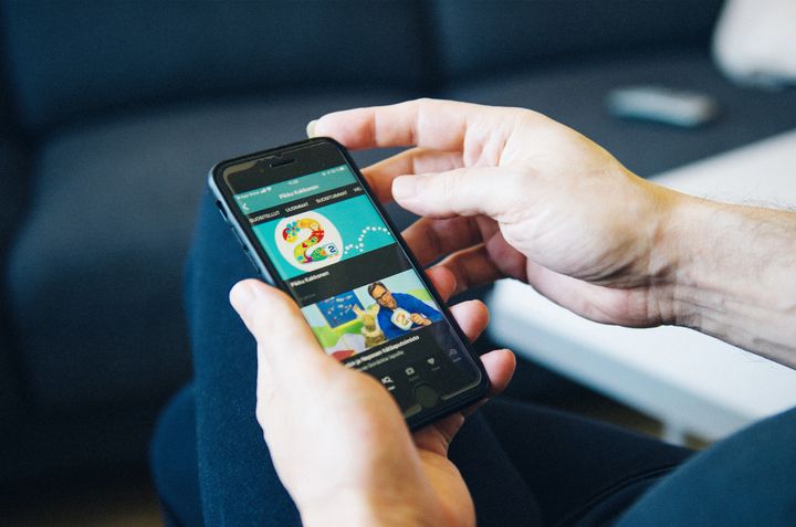 Henkilö selaa Yle Areenaa älypuhelimella, näyttö kuvassa.